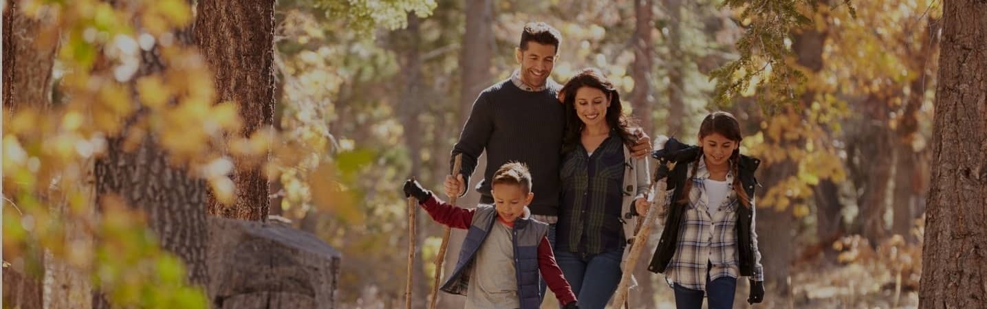 Happy hispanic family walking in the forest