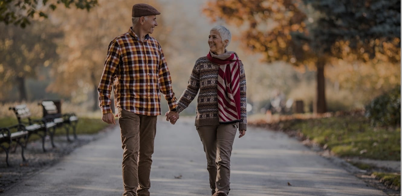 Happy senior couple talking while walking in the park