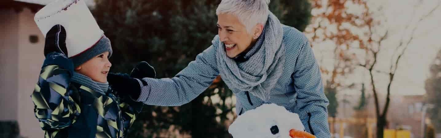 grandmother and grandson making a snowman