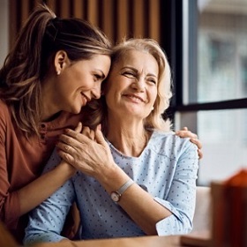 Mother and daughter smiling and hugging