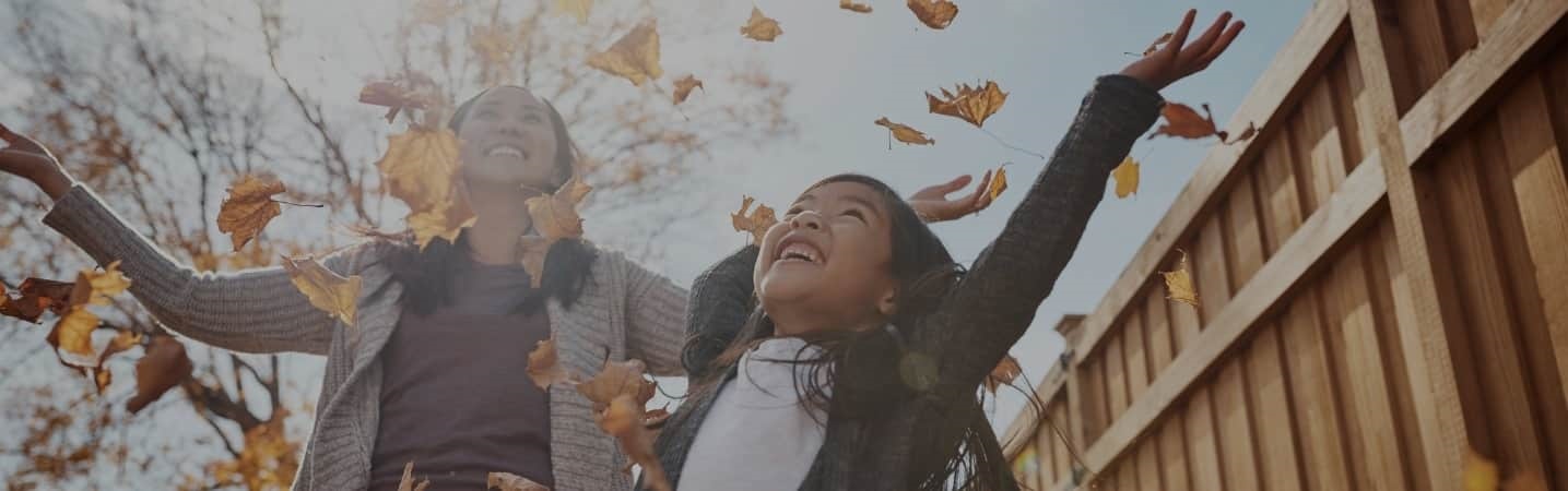 Asian mom and daughter enjoying the fall leaves