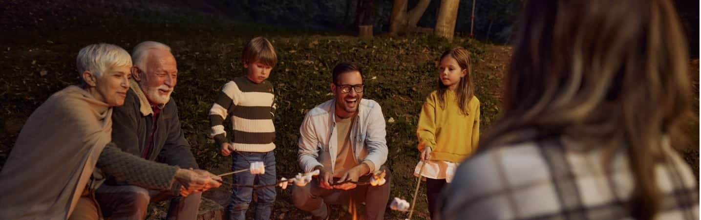 Family roasting marshmallows over bonfire